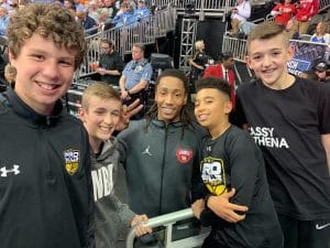 Five boys pose for a photo at a basketball game